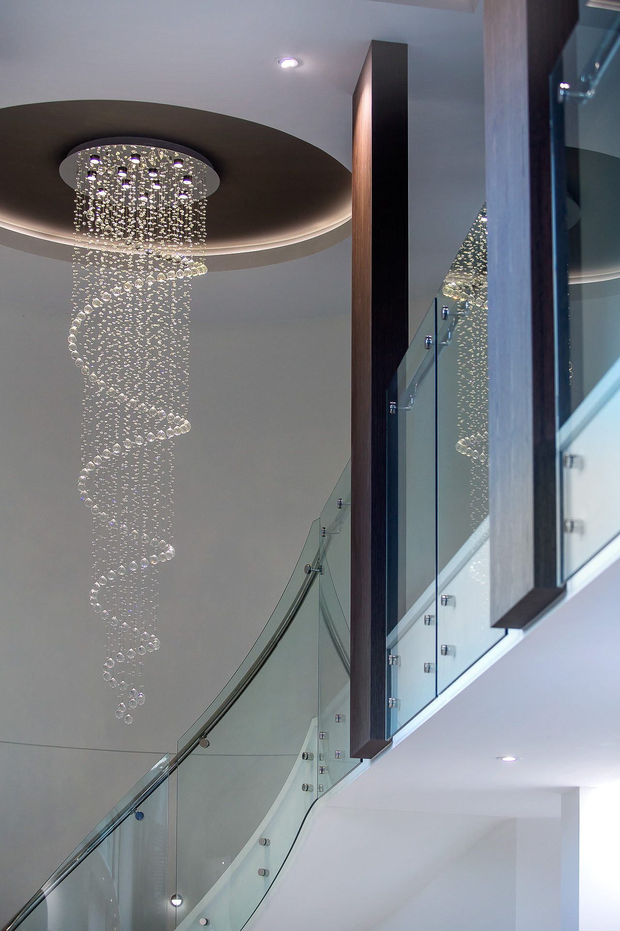 Luxury home, spiral staircase, stairs, chandelier, spiral lights, curved glass, stunning entry, minka joinery