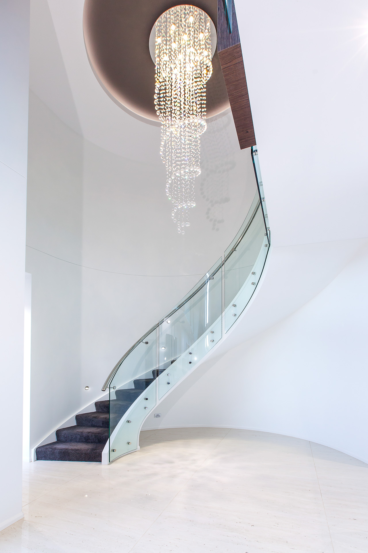 Luxury home, spiral staircase, stairs, chandelier, spiral lights, curved glass, stunning entry, minka joinery